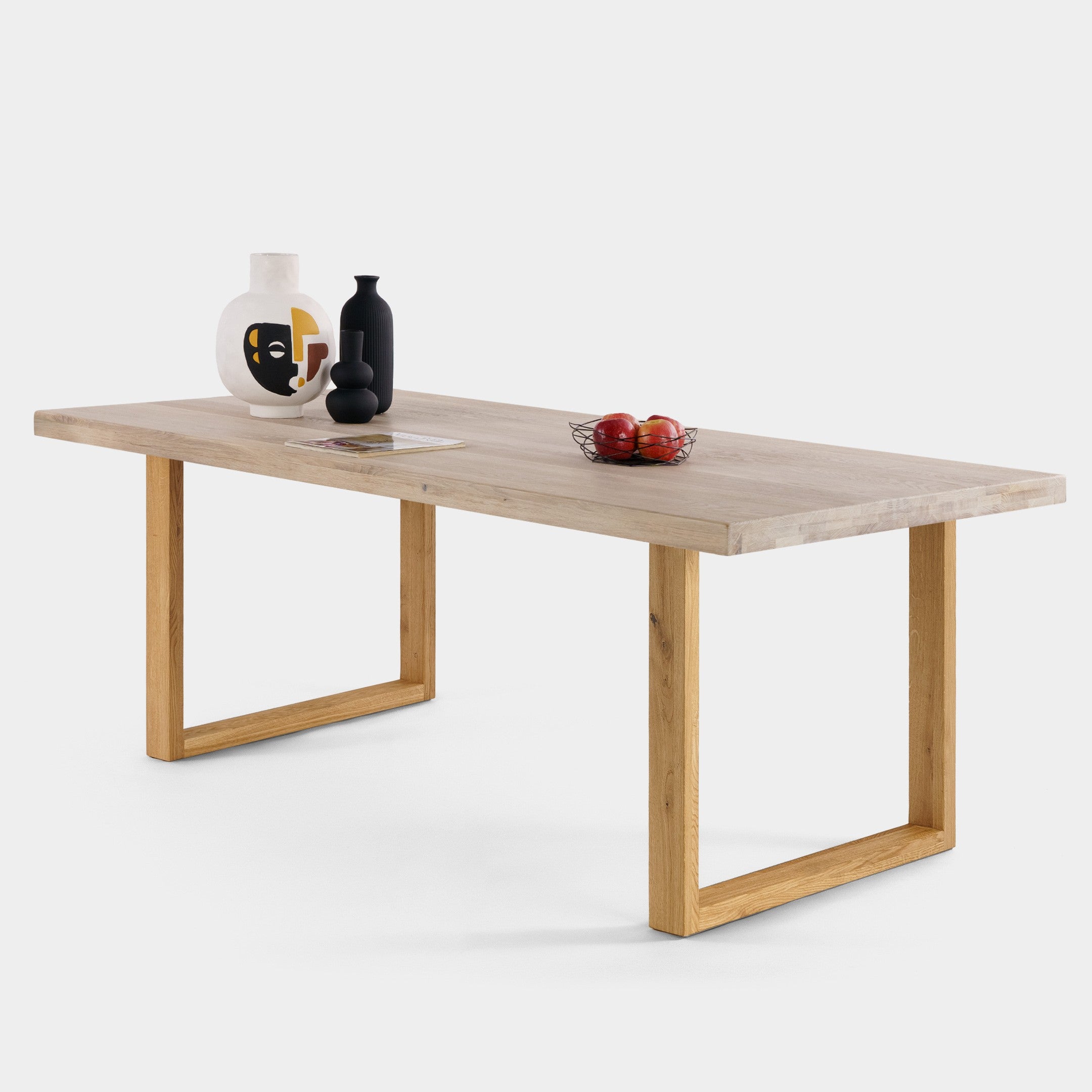 Mesa de comedor Avara de roble macizo blanqueado con patas en U de roble, canto ondulado