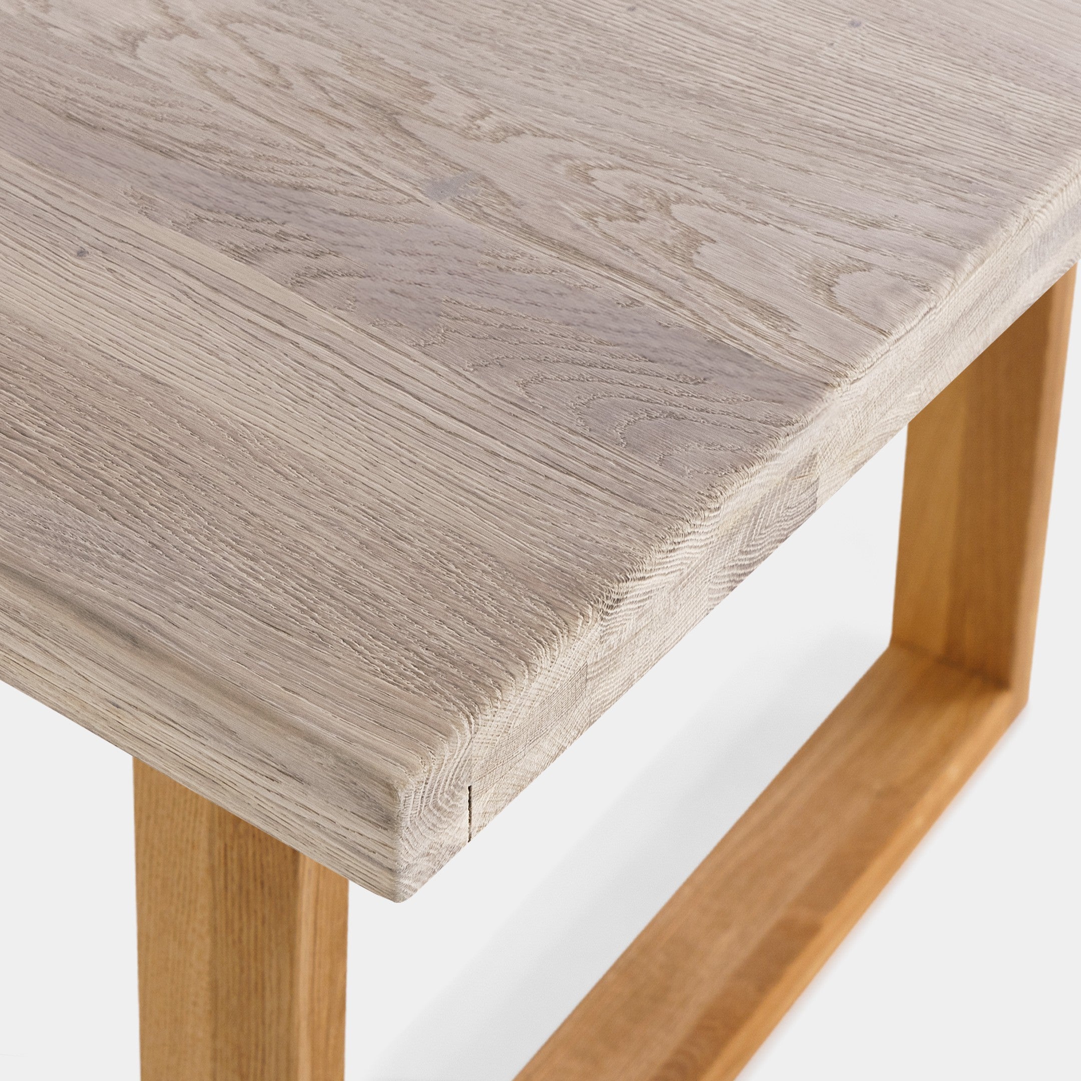 Mesa de comedor Avara de roble macizo blanqueado con patas en U de roble, canto ondulado