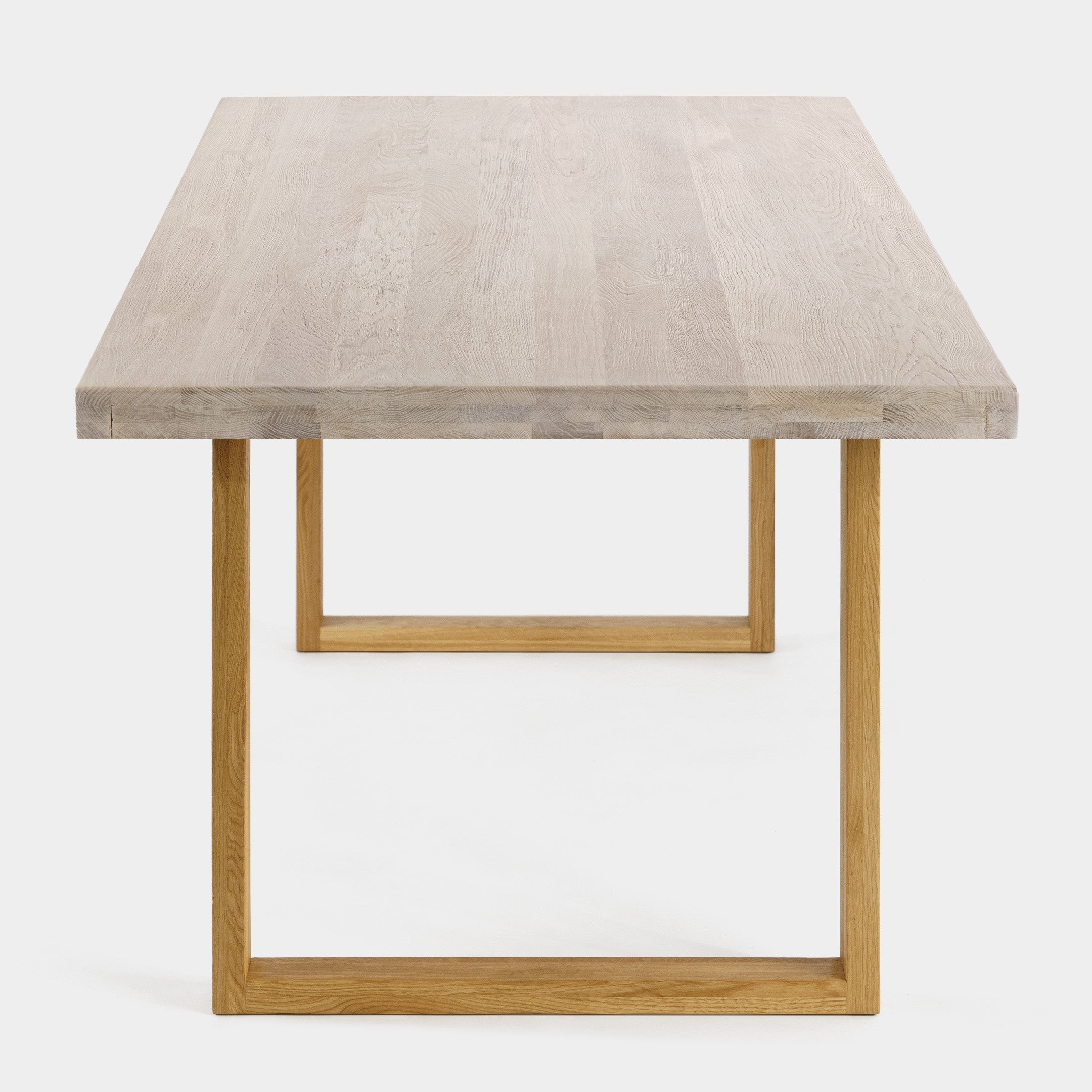 Mesa de comedor Avara de roble macizo blanqueado con patas en U de roble, canto recto